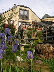 una casa con flores púrpuras delante de ella en L'Arcouli, en Sers