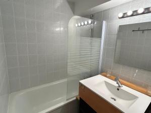 ein Badezimmer mit Waschbecken, Badewanne und Spiegel in der Unterkunft Studio charmant au centre de la station montagne, idéal pour 2 à 4 personnes - FR-1-814-4 in Besse-et-Saint-Anastaise + 8 Fotos