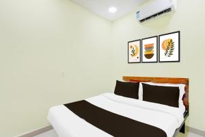 a bedroom with a white bed and pictures on the wall at Super Hotel O Moula Ali Neredmet in Hyderabad +38 photos