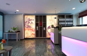 a lobby with a bar with pink lighting at Leonardo Hotel Nürnberg in Nürnberg