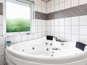 a white bath tub in a bathroom with a window at 5 star holiday home in Fjerritslev in Fjerritslev