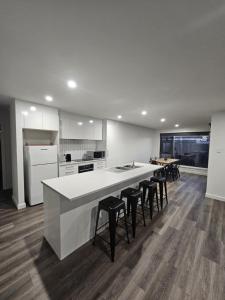 a kitchen with a large white counter and stools at George Town Villa - Outdoor Alfresco - aircon FREE WIFI - Central location near MTB Trails in George Town