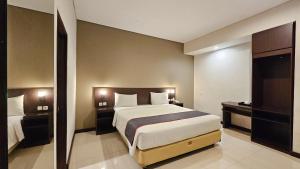 a bedroom with a large bed in a room at Grage Hotel Malang by TOS in Malang