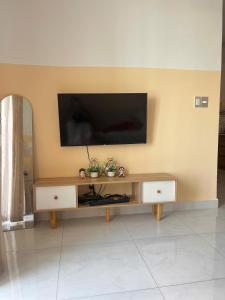 a living room with a television on a wall at Homestay Ngôi Nhà Nhỏ in Kinh Dinh