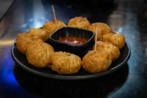 a plate of food with a bowl of dipping sauce at Nahargarh view Hotel in Jaipur