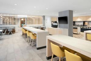 a cafeteria with yellow chairs and tables and a kitchen at TownePlace Suites Pigeon Forge in Pigeon Forge