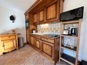 a kitchen with wooden cabinets and a microwave at Appartement charmant et central à Samoëns, proche commerces et ski-bus - FR-1-624-54 in Samoëns +11 photos