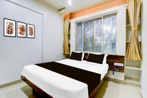 a bedroom with a large bed and a window at Super Collection O Balewadi formerly Woods Regency in Pune
