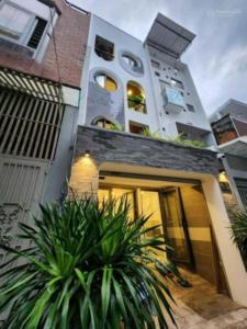 a large white building with plants in front of it at Lunaria Maison - Local Side in Ho Chi Minh City