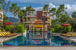 a pool at the resort with chairs and umbrellas at Mövenpick Resort Bangtao Beach Phuket in Bang Tao Beach