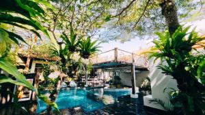 a swimming pool in a garden with trees at Pondok Baruna Frangipani in Nusa Lembongan