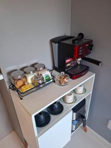 a table with a coffee maker and food on it at Smart Residence Praia in Maceió