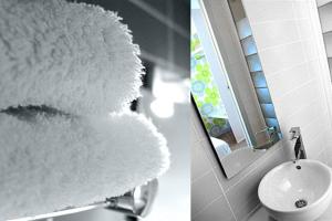 un ours en peluche suspendu sur le côté d'un miroir de salle de bains dans l'établissement Hôtel Oxo, à Biarritz