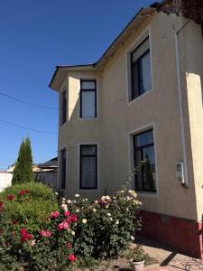 a house with pink flowers in front of it at Mama Nuris guest house in Karakol