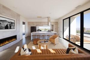 a living room with a couch and a fireplace at White Casita by Fieldtrip - Modern w Pool Spa in Joshua Tree