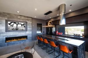a kitchen with a bar with a fireplace at Black Casita by Fieldtrip - Bold Villa w Pool Spa in Joshua Tree