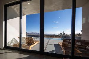a room with a large window with chairs and a pool at Black Casita by Fieldtrip - Bold Villa w Pool Spa in Joshua Tree