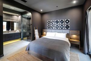 a bedroom with a large bed and a shower at Black Casita by Fieldtrip - Bold Villa w Pool Spa in Joshua Tree +9 photos