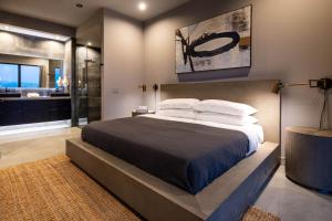 a bedroom with a large bed and a bathroom at The Coza by Fieldtrip - Modern Retreat w Pool Spa in Joshua Tree +17 photos