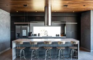 cocina con barra con taburetes en The Box by Fieldtrip - Architectural Villa w Pool Spa, en Joshua Tree