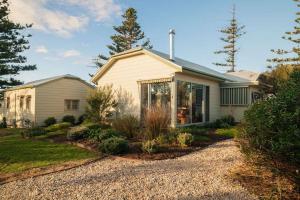 a white house with a garden in front of it at Chiton Cottage by the Sea - Restaurants, Bikes, Pets in Hayborough