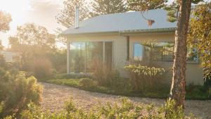 a small white house with a window on the side of it at Chiton Cottage by the Sea - Restaurants, Bikes, Pets in Hayborough