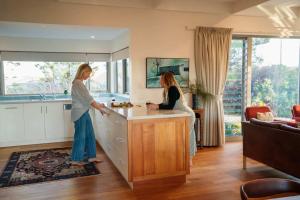 two women standing in a kitchen with a counter at Chiton Cottage by the Sea - Restaurants, Bikes, Pets in Hayborough