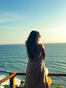 a woman in a dress looking at the ocean at Asteya boutique stays in Varkala