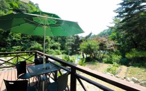 InjeにあるInje Good Morning Pensionのデッキの緑の傘を持つテーブル