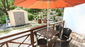 InjeにあるInje Good Morning Pensionのデッキのパラソル下にテーブルと椅子