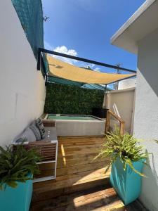 サンファンにあるIsmael Rivera Villa 1 Ocean Park 4bd 2bの温水浴槽と2つの鉢植えのあるパティオ