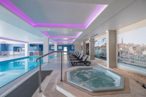 a swimming pool with a hot tub in a building at Vila Gale Porto - Centro in Porto