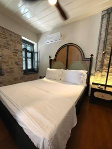 アイワルクにあるCourtyard Home w Lesvos Island Viewの白いシーツが敷かれた大きなベッドのある寝室