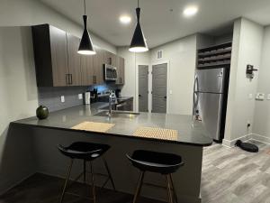 eine Küche mit einer großen Insel mit zwei Barhockern in der Unterkunft Zen Clone Lab in Frisco
