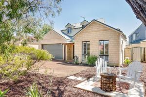 una casa con dos sillas blancas en un patio en Driftwood - True Beachside Bliss with Games Galore, en Dunsborough