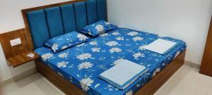 a bed with blue sheets and two books on it at Kishori kripa in Mathura
