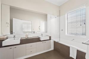 ein weißes Badezimmer mit zwei Waschbecken und einem Spiegel in der Unterkunft Casa Indigo - Modern Bushland Retreat by the Sea in Dunsborough + 19 Fotos
