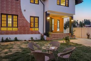 a patio with chairs and a table in front of a house at Badakshan Bliss in Srinagar