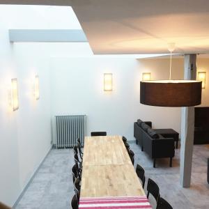 une salle de conférence avec une table et des chaises en bois dans l'établissement Appartements Rue Lemoine XXL, à Angers