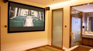 a flat screen tv hanging on a wall with chairs at James Joyce Coffetel Shijiazhuang Wanda Plaza Tangu Metro Station in Shijiazhuang +90 photos
