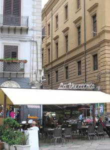 a restaurant with tables and chairs in front of a building at meli20home in Palermo