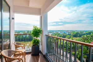 a balcony with chairs and a view of the city at Little Oasis - An Eco Friendly Hotel & Spa in Hoi An