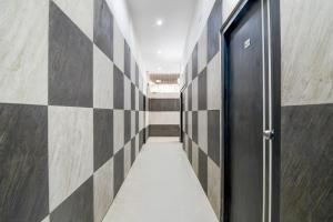 a hallway with a black door and a tile wall at Super Collection O Minto Park Formerly Hotel Gardenia in Ballygunge