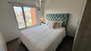 a bedroom with a large bed with a large window at Apartamento cerca de Embajada Americana en Quito in Quito +9 photos