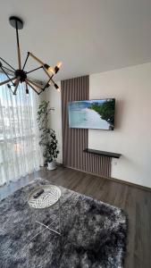 a living room with a flat screen tv and a chair at Apartamento cerca de Embajada Americana en Quito in Quito