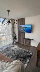 a living room with a couch and a tv at Apartamento cerca de Embajada Americana en Quito in Quito
