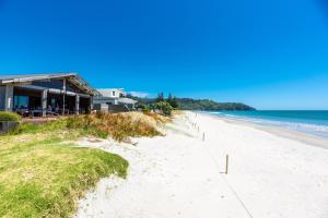 a view of a beach with a house and the ocean at The Cottage - Waihi Beach Holiday home in Waihi Beach