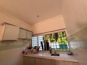 a kitchen with a sink and a window at PD GREEN Homestay in Port Dickson