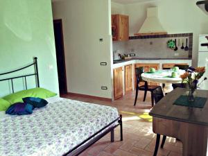 a bedroom with a bed and a kitchen with a table at Mini Appartamenti Nonna Nella in Barbarasco