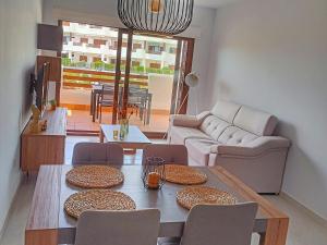 a living room with a table and chairs and a couch at Apartamento moderno con piscina, a 500m de la playa, San Juan de los Terreros - ES-376-41 in Pulpí